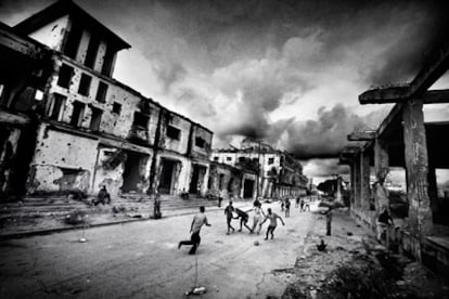 Un grupo de niños juega al fútbol en una calle de Mogadiscio entre edificios en ruinas por los enfrentamientos armados. Esta fotografía forma parte de <i>Somalia en el fin del mundo</i>, reportaje fotográfico galardonado con el Premio Ortega y Gasset de Fotografía 2009, publicado en el <i>Magazine</i> de <i>La Vanguardia</i> del 1 de febrero de 2009.