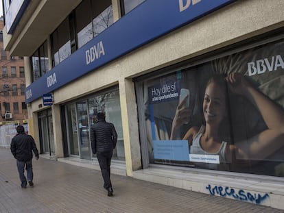 Dos personas caminan fuera de la sede de una sucursal del banco BBVA en Santiago de Chile.