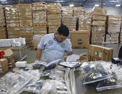 Un operario revisa varios paquetes dispuestos para ser enviados de EE UU a México.