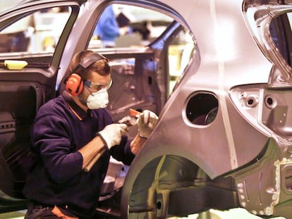 Un alumno, trabajando la chapa de un coche