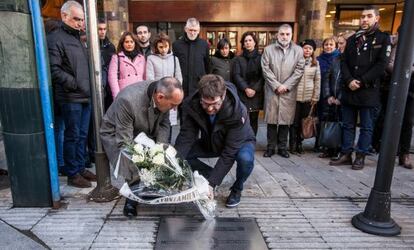 El diputado general de Álava, Ramiro Gonzalez y el alcalde de Vitoria a la derecha, Gorka Urtaran, ambos agachados colocan un ramo de flores en el lugar en el que asesinaron a Velasco