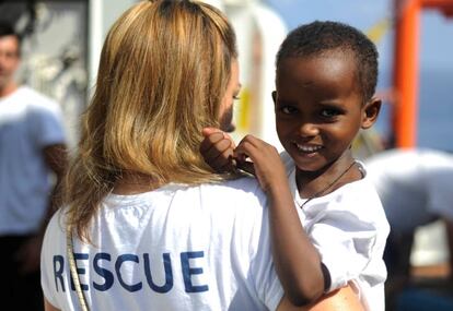 Una humanitaria del Aquarius con uno de los niós rescatados a bordo.