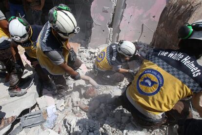 Miembros de la Defensa Civil Siria conocidos como 'Cascos Blancos' tratan de sacar a un hombre de los escombros de un edificio después de un ataque aéreo de las fuerzas del régimen sirio en Maar Shurin (Siria), el 16 de julio de 2019. Los ataques aéreos del régimen mataron a nueve civiles en el noroeste de Siria, una zona que de acuerdo con el Observatorio Sirio de los Derechos Humanos ha sido que es objetivo durante meses de ataques del régimen sirio y de bombardeos rusos.