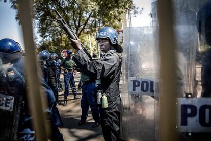 Los antidisturbios zimbabuenses guardan las puertas de las Rainbow Towers, donde se anunciaron los resultados de las elecciones del país africano.