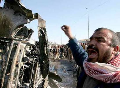 Un iraquí grita ante los restos del minibús bomba que explosionó ayer en el centro de Kufa, una ciudad a 160 kilómetros al sur de Bagdad.