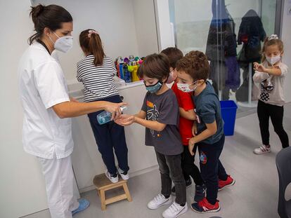 La enfermera del colegio Aldapeta María de San Sebastián ofrece gel hidroalcohólico a alumnos de primaria.