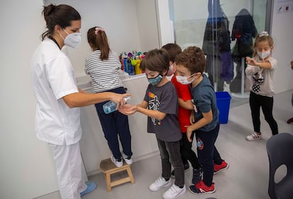 La enfermera del colegio Aldapeta María de San Sebastián ofrece gel hidroalcohólico a alumnos de primaria.