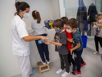 Varios niños hacen cola para usar gel hidroalcohólico en un colegio de San Sebastián.