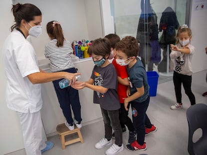 La enfermera del colegio Aldapeta María de San Sebastián ofrece gel hidroalcohólico a alumnos de primaria.