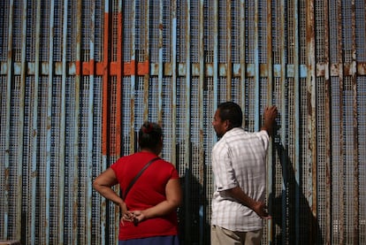 Unas personas hablan con familiares a través del muro que separa a México y los Estados Unidos, en Tijuana (México).
