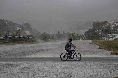 Un hombre pasea en bicicleta por campos cubiertos de ceniza volcánica un día después de la erupción del volcán La Soufriere, en Kingstown, el sábado 10 de abril.