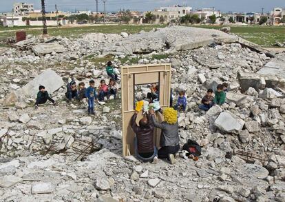 Dos actores sirios entretienen a un grupo de niños a través de un improvisado teatro de títeres instalado entre los escombros de los edificios derrumbados en la ciudad de Saraqeb (Siria), el 27 de marzo de 2019. De acuerdo con Amnistía internacional, este jueves se registraton en Siria ataques por parte de las fuerzas gubernamentales sirias, apoyadas por Rusia, que alcanzaron un hospital, un banco de sangre y otras instalaciones médicas, así como una panadería y una escuela en pueblos y ciudades bajo el control de grupos armados de oposición en Idlib.