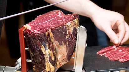 Un empleado corta la carne de vacuno curada y ligeramente ahumada de Cecinas Nieto.