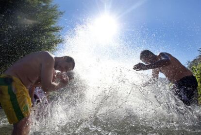 Unos jóvenes combaten el calor refrescándose en el río Genil en Granada.