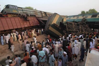 Paquistaníes se acercan al lugar de colisión de dos trenes en las afueras de Multan (Pakistán).