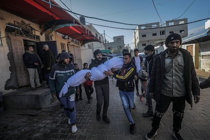 Varios hombres trasladan el cadáver de un niño de ocho años muerto este jueves en un ataque israelí contra el campo de refugiados de Al Bureij, en Gaza.