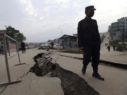 Un soldat al costat d&#039;una esquerda al terra de Katmand&uacute;.