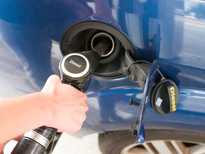 Un conductor reposta combustible diésel en una gasolinera.