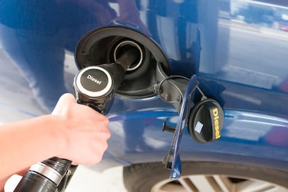 Un conductor reposta combustible diésel en una gasolinera.