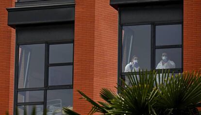 Varios trabajadores miran por la ventana desde el interior de la residencia de ancianos Monte Hermoso, este miércoles, en Madrid.