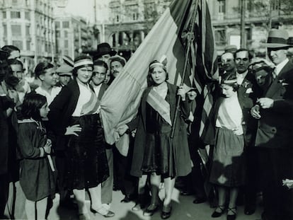 Mujeres portando cintas tricolores y la bandera republicana en la plaza de Catalunya de Barcelona el 15 de abril de 1931.