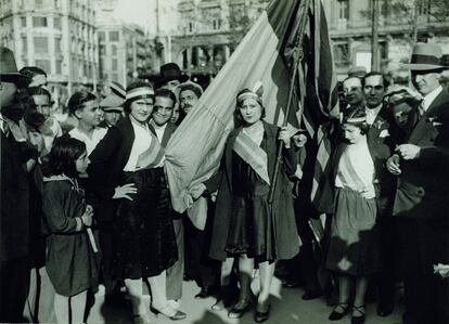 Mujeres portando cintas tricolores y la bandera republicana en la plaza de Catalunya de Barcelona el 15 de abril de 1931.