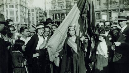 Mujeres portando cintas tricolores y la bandera republicana en la plaza de Catalunya de Barcelona el 15 de abril de 1931.
