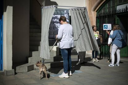 Una ciudadana escoge su papeleta en la cabina de votación de la escuela Infant Jesus, en Barcelona.