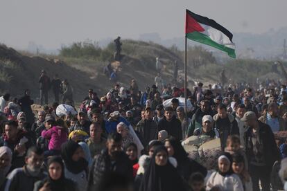 Una bandera Palestina es portada por un gazatí durante el retorno a su hogar en el norte de la Franja, este lunes. 