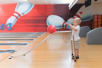 Un niño juega a los bolos.