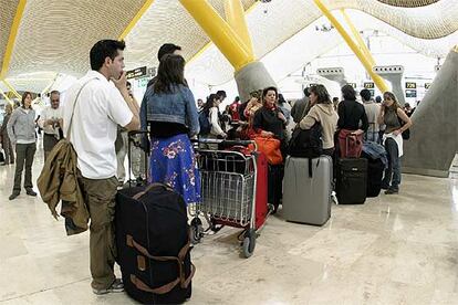 Un grupo de pasajeros hacen cola en la T-4 de Barajas (Madrid) la pasada Semana Santa.