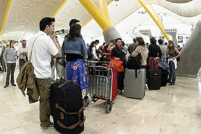 Un grupo de pasajeros hacen cola en la T-4 de Barajas (Madrid) la pasada Semana Santa.