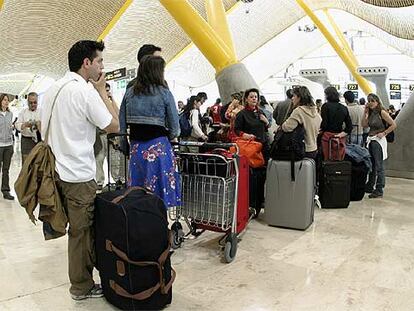 Un grupo de pasajeros hacen cola en la T-4 de Barajas (Madrid) la pasada Semana Santa.