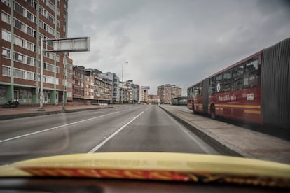 Un bus articulado de Transmilenio atraviesa las avenidas despejadas de Bogotá.