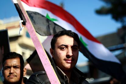 Ciudadanos sirios con la bandera nacional se manifiestan en Qamishli pidiendo protección del ejercito de Siria, tras las amenazas de Turquía de llevar a cabo una nueva ofensiva como consecuencia de la decisión de Estados Unidos de retirar las tropas, el 23 de diciembre de 2018.