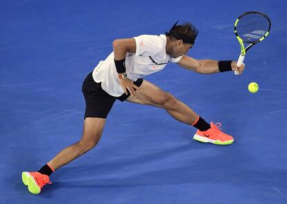 El tenista español Rafael Nadal devuelve la pelota con su brazo izquierdo.
