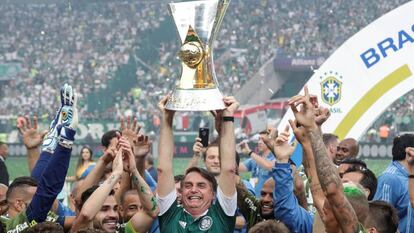 Bolsonaro ergue a taça de campeão do Palmeiras no Allianz Parque.