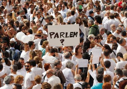 Una mujer sostiene un cartel bajo el título "Parlem?" durante la concentración en la plaza de Sant Jaume de Barcelona.
