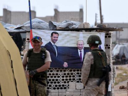 Militares rusos en un 'checkpoint' con un póster de El Asad y Putin, en el oeste de Siria.