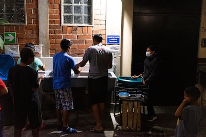 Algunos migrantes de paso por Guatemala piden refugio por una noche en el refugio dirigido por los misioneros scalabrinianos. Buscan una cama donde acostarse y olvidar el día. En la imagen, unos huéspedes friegan los platos después de la cena.