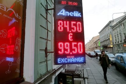 Un hombre pasa por delante de una oficina de cambio de divisas en Moscú, Rusia, donde se muestra el desplome del rublo