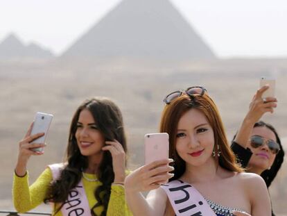 Un grupo de 'misses' se toman selfis frente a las pirámides de Egipto. 