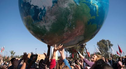 Asistentes a la COP222 juegan con un globo gigante que representa al planeta Tierra en Marrakech.