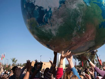 Asistentes a la COP222 juegan con un globo gigante que representa al planeta Tierra en Marrakech.