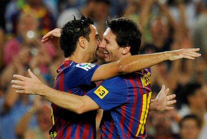 Xavi y Messi se abrazan durante un partido