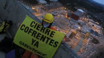 Un activista despliega una pancarta en una de las torres de refrigeración de la central nuclear.