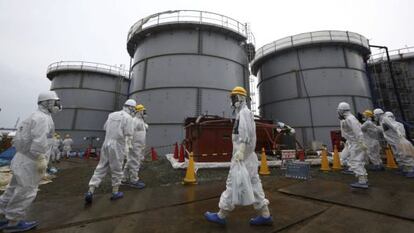 Empleados de Tokyo Electric Power pasan por delante de tanques con agua radioactiva en la central nuclear de Fukushima, 7 de noviembre de 2013.