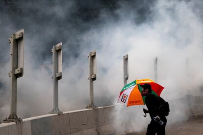 Un manifestante antigubernamental huye del gas lacrimógeno durante una manifestación en el distrito de Wan Chai en Hong Kong.