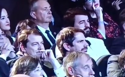 En una imagen captada de RTVE, Juan García-Gallardo, a la derecha, con barba, durante el discurso de Pedro Almodóvar. Una fila delante, Alfonso Fernández Mañueco (con la mano en la cara), junto al ministro de Cultura, Ernest Urtasun.  

