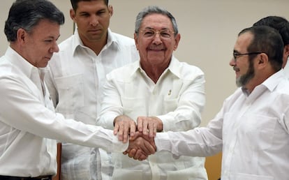 O presidente colombiano, Juan Manuel Santos, o chefe das FARC, Timochenko, e o presidente de Cuba, Raúl Castro, apertam as mãos durante uma reunião em Havana. O Governo e as FARC se deram seis meses para assinar a paz em Colômbia.